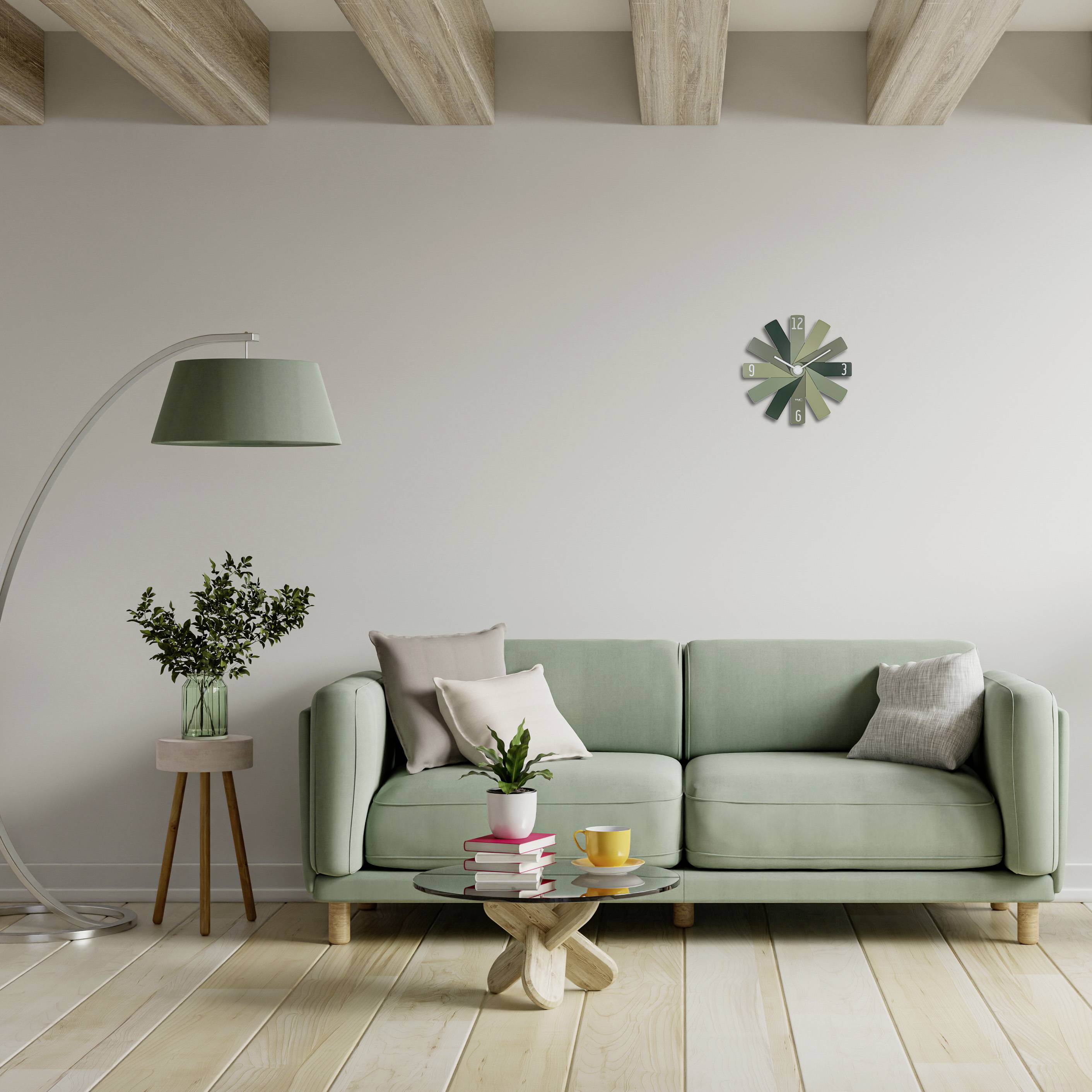 Ein Wohnzimmer mit einem grünen Sofa, einem runden Holztisch mit Tassen, einer Stehlampe, einer Pflanze und einer Wanduhr.