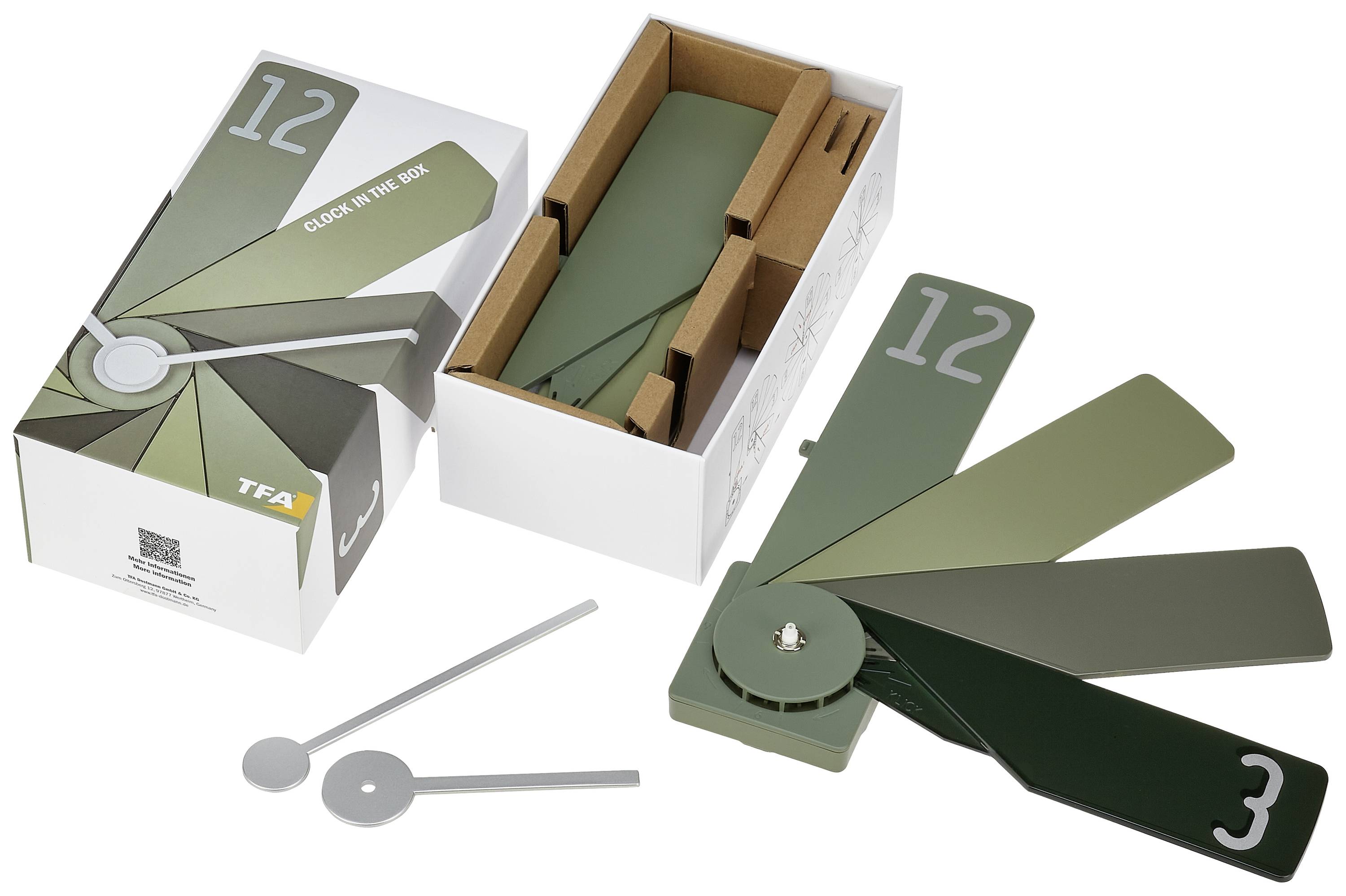 Verspielte grüne Fächeruhr mit verschiedenen Farbtönen, zeigt Stunden an. Verpackung geöffnet, zwei graue Zeiger liegen daneben.