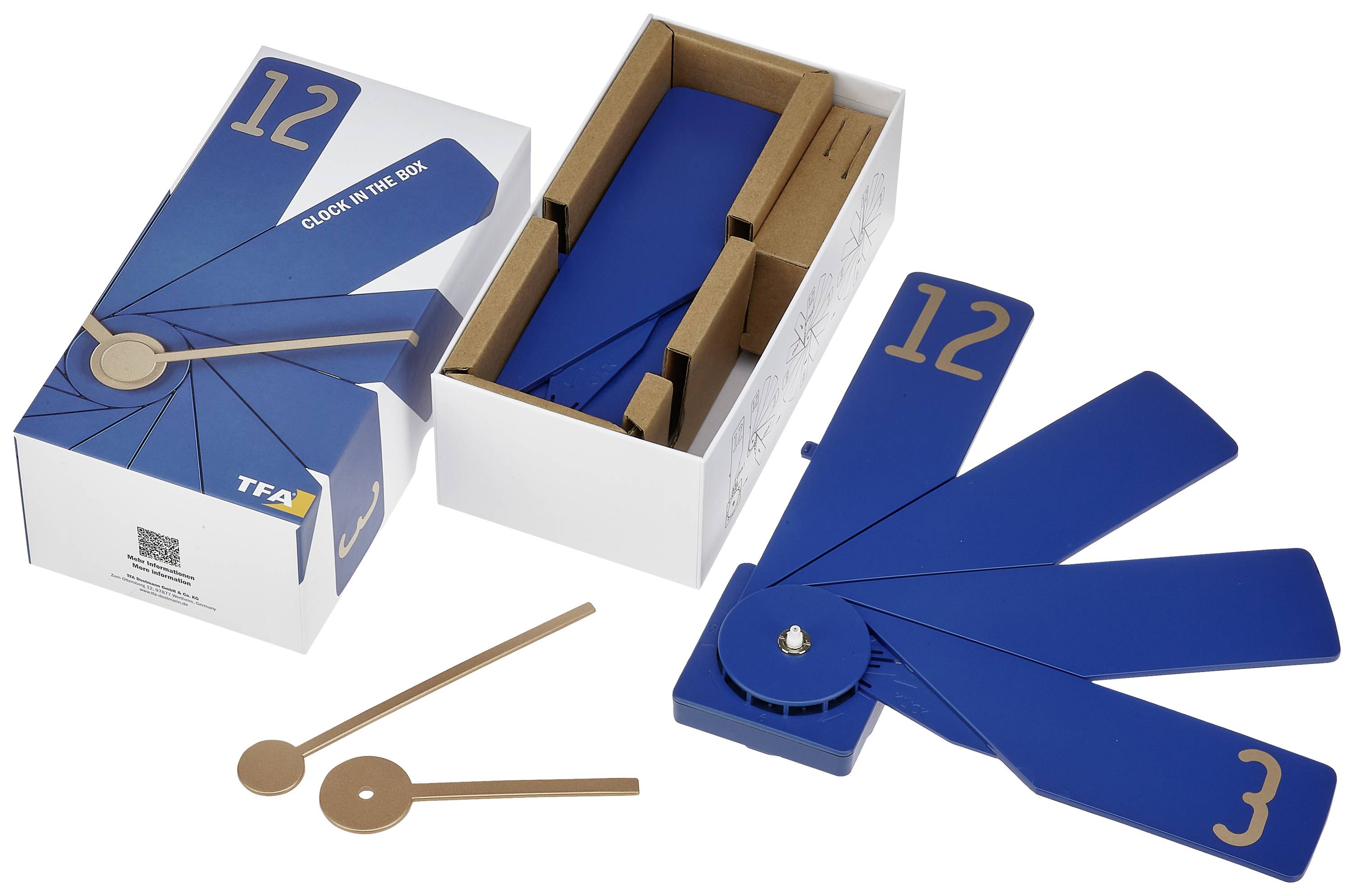 Blauer Fächer-Wecker in geöffneter Schachtel, zeigt Ziffernblätter 12 und 3. Daneben liegen Zeiger und Verpackungsteile.