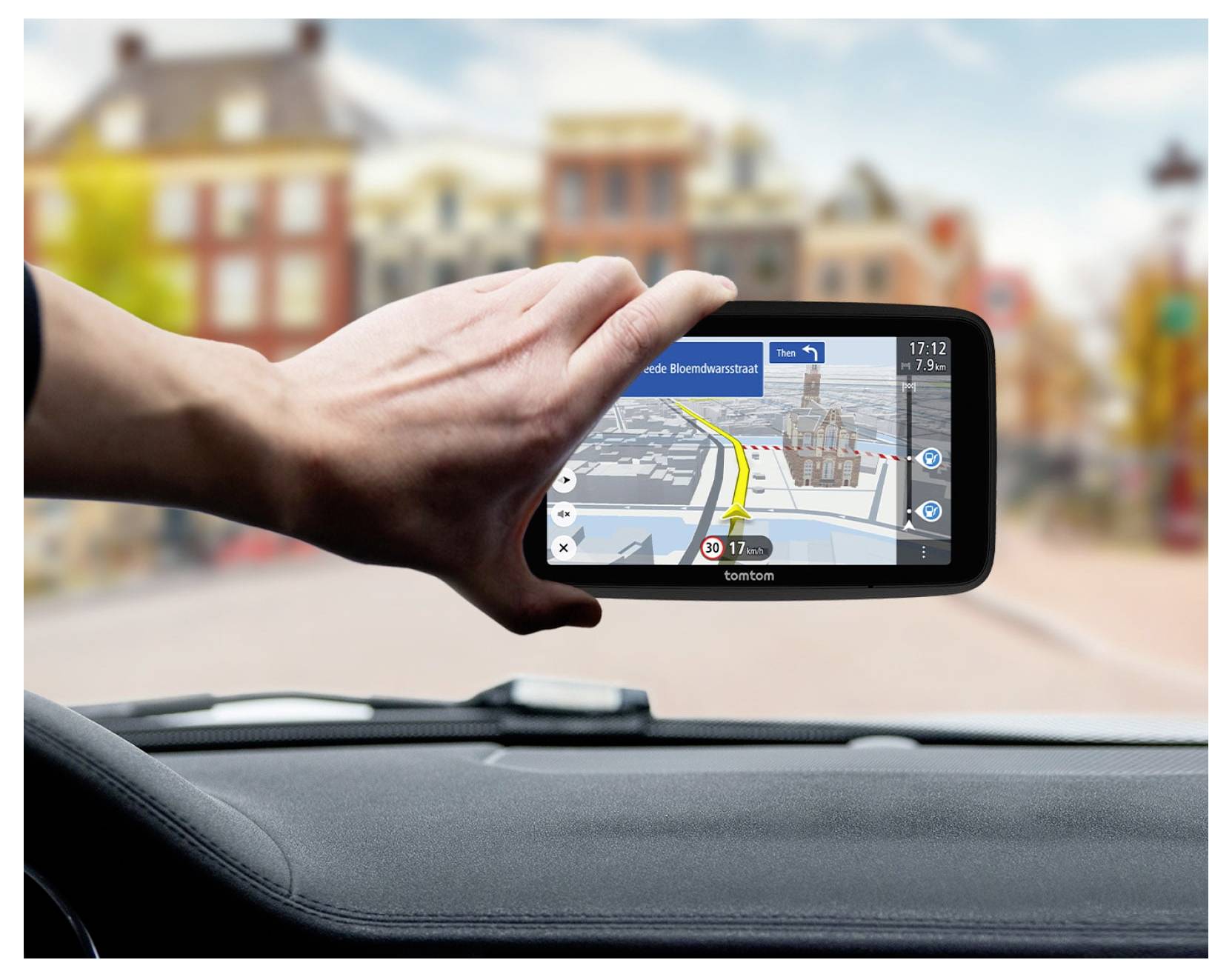 Hand hält ein Smartphone, das eine GPS-Navigationskarte mit Routenrichtungen zeigt, während es von innen in einem Auto betrachtet wird.