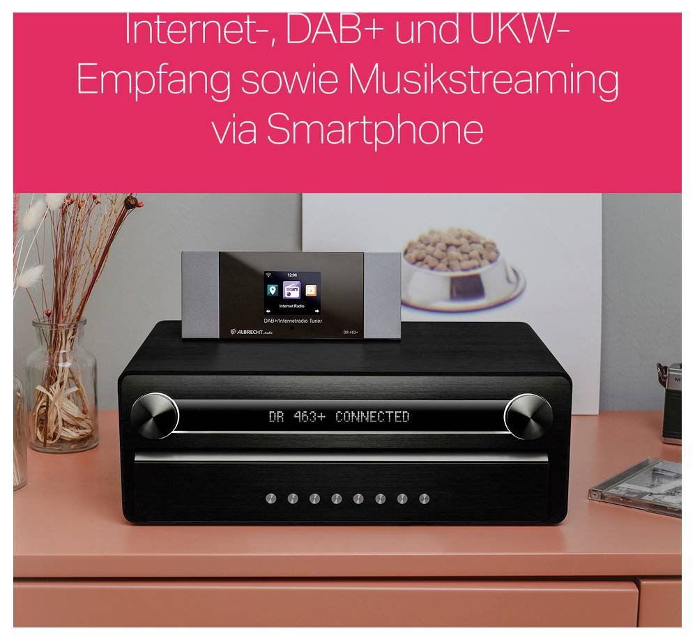 Ein schwarzes Digitalradio steht auf einem Tisch. Oben zeigt ein Display 'DR 463+ CONNECTED'. Im Hintergrund ein Teller mit Gebäck.