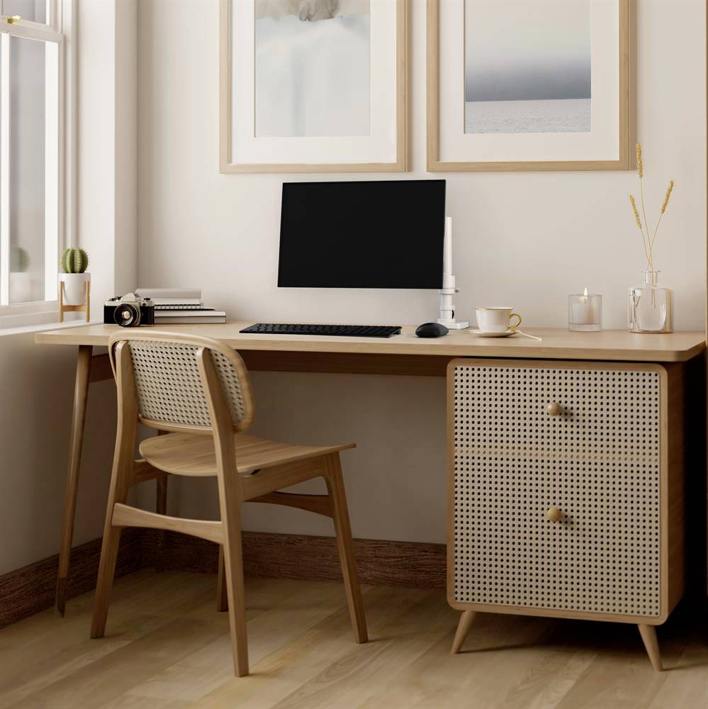 Ein minimalistischer Schreibtisch mit Computer, Tastatur und Maus. Holzstuhl und Dekorationen verleihen dem Raum eine warme Atmosphäre. Fenster im Hintergrund.