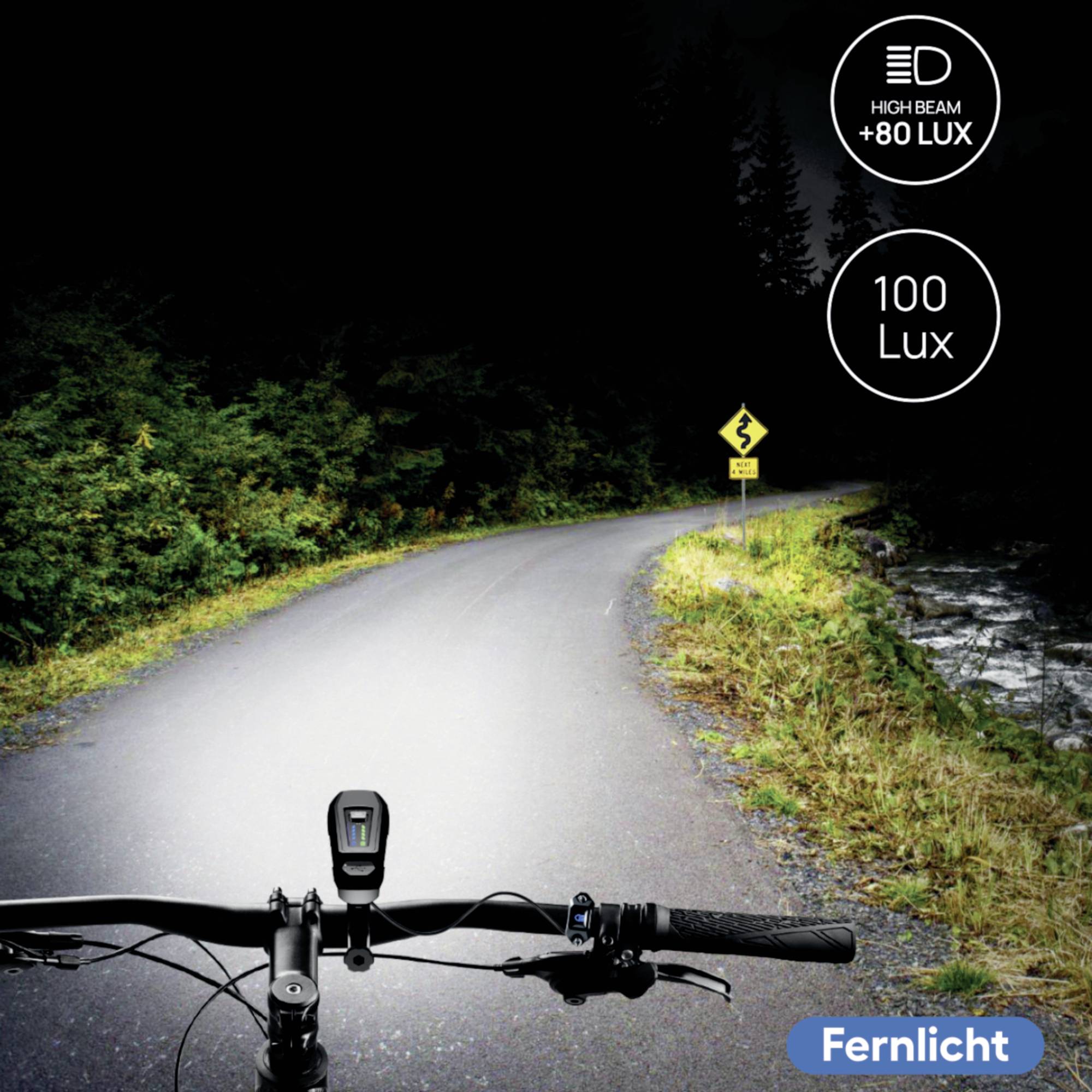 Ein Fahrrad fährt nachts auf einer kurvigen Straße mit starkem Fernlicht, das die Umgebung beleuchtet. Fernlicht: +80 Lux, 100 Lux.