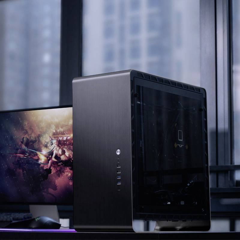 Ein schwarzer Computer-Tower steht auf einem Tisch vor einem Fenster, daneben ein Monitor mit einem Fantasy-Computerspiel.