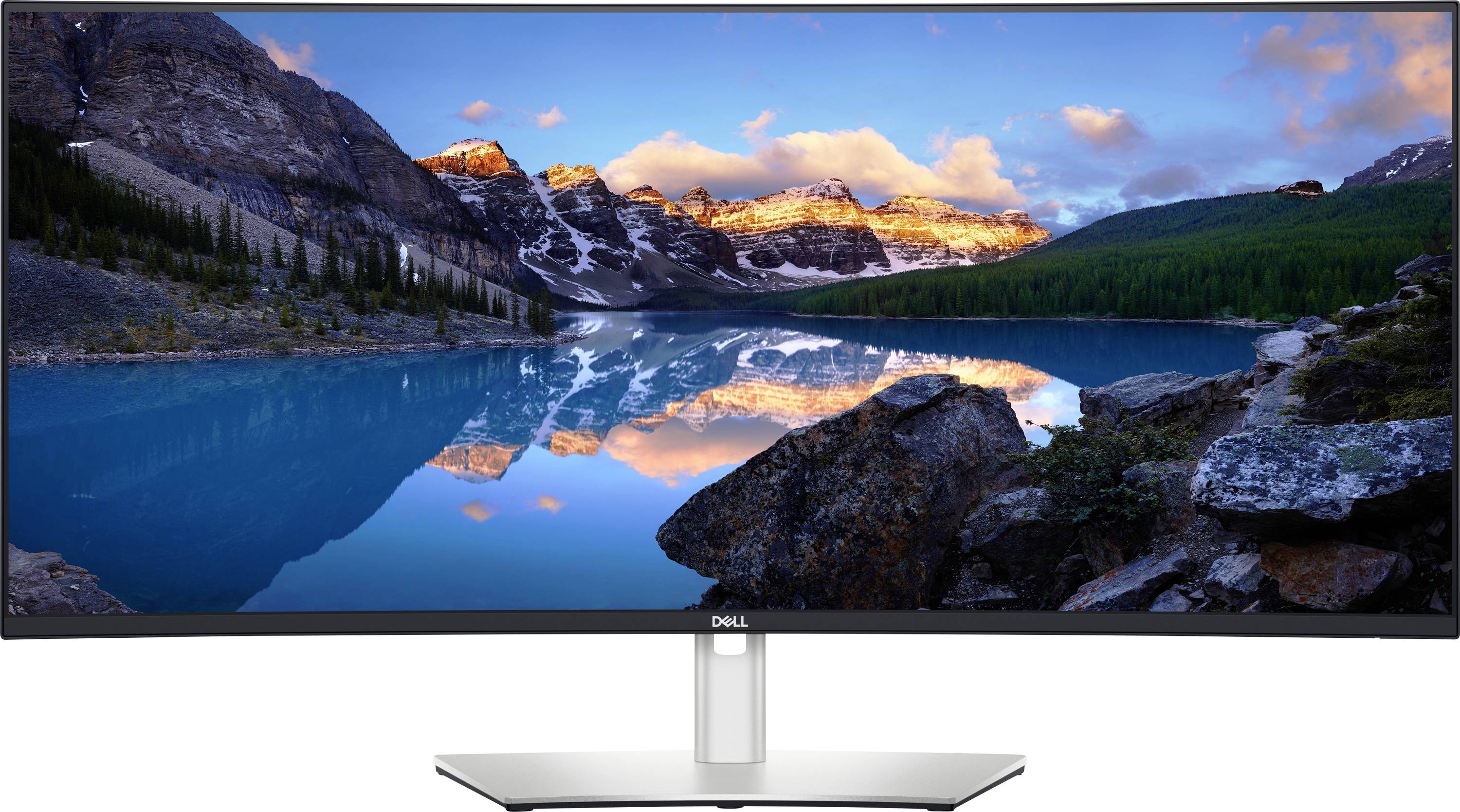 Ein Dell-Monitor, der eine malerische Berglandschaft zeigt, mit einem See, der die von der Abendsonne beleuchteten Berggipfel spiegelt, und einem klaren blauen Himmel.