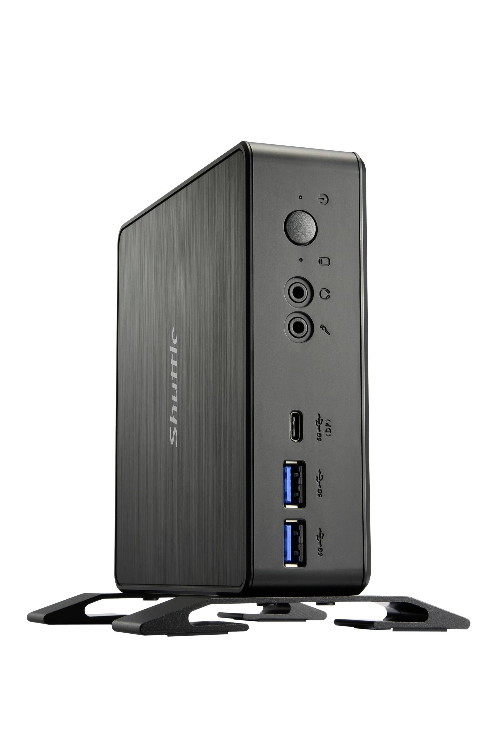 Ein schwarzer Shuttle Mini-PC steht aufrecht auf seinem Ständer. Die Vorderseite zeigt Anschlüsse für USB, Audio und ein Power-Knopf.