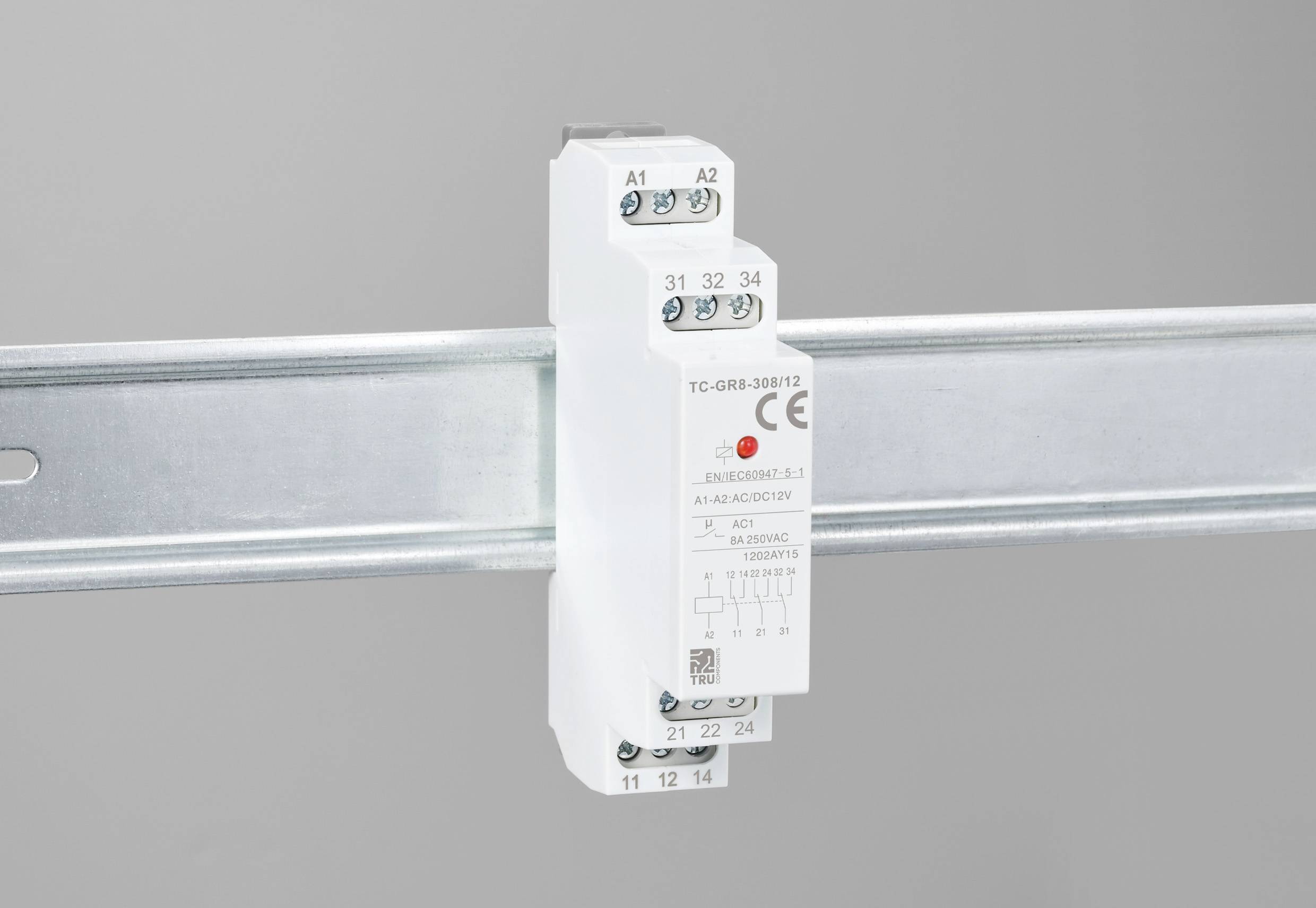 Ein elektrisches Relais ist auf einer Metallschiene montiert, mit mehreren markierten Anschlüssen für die Verdrahtung.
