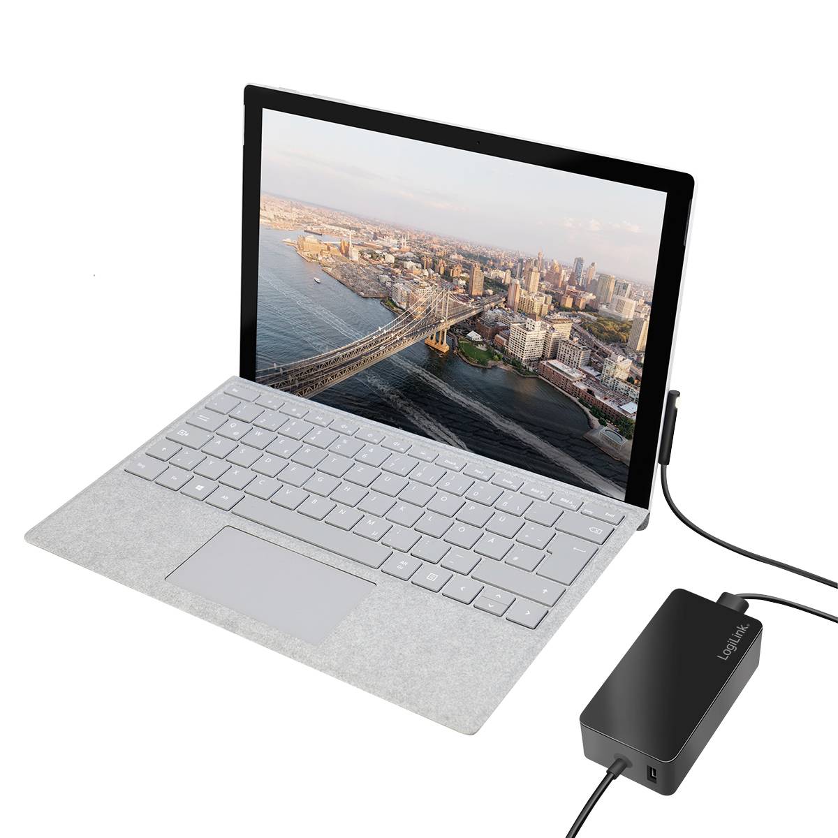 Ein Laptop mit einem Bild von einer Küstenstadt auf dem Bildschirm wird an eine externe Festplatte angeschlossen.