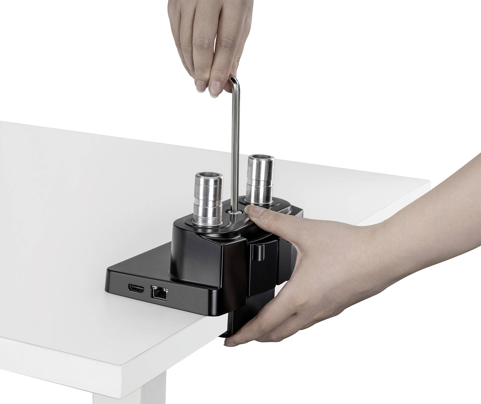 Hände befestigen ein Gerät mit einem Inbusschlüssel an einem weißen Tisch. Es sieht aus wie eine Klemme oder Halterung.