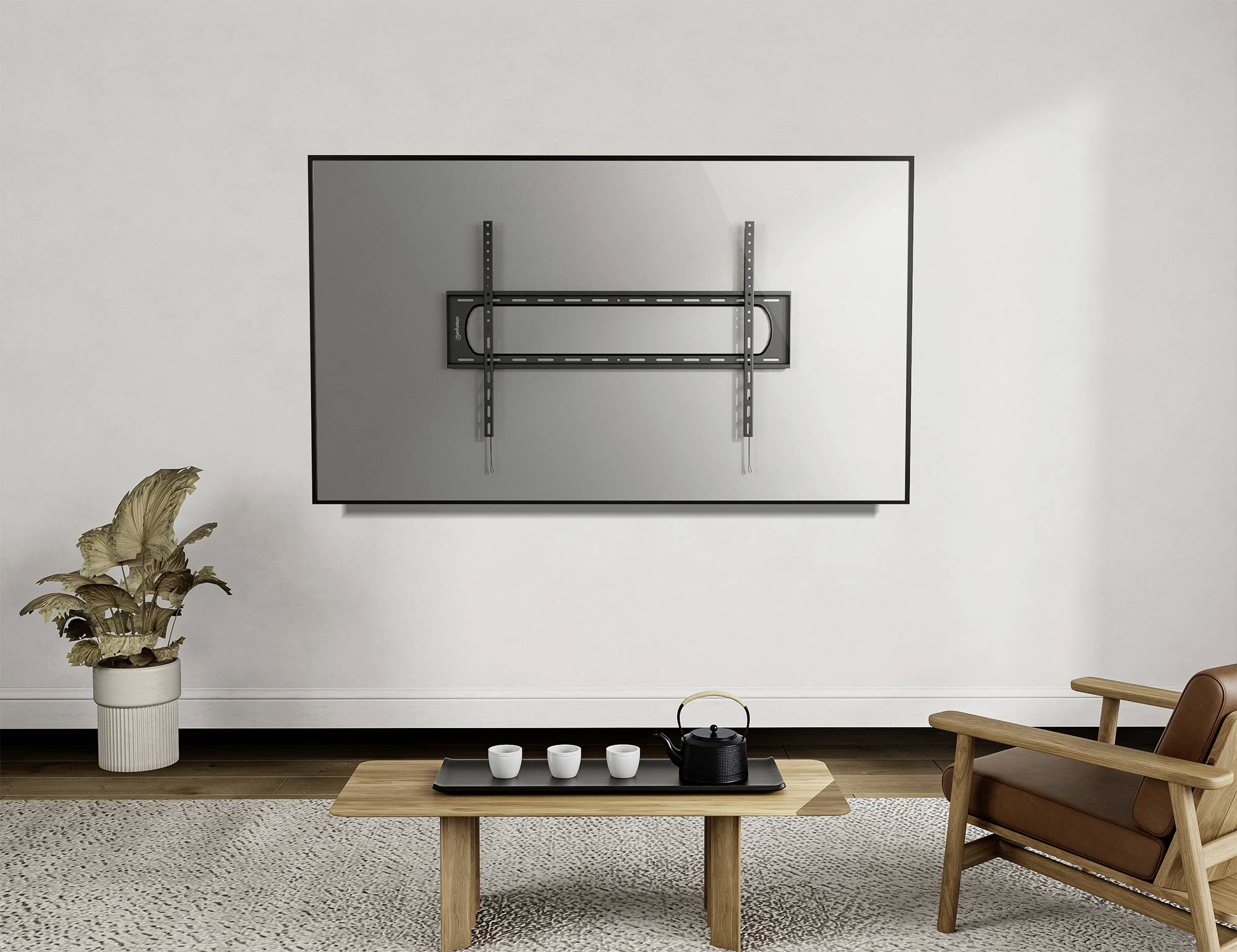 Ein Wohnzimmer mit einer hellen Wand. Ein TV-Wandhalter ohne Fernseher ist montiert. Darunter steht ein Holztisch mit Teeservice.