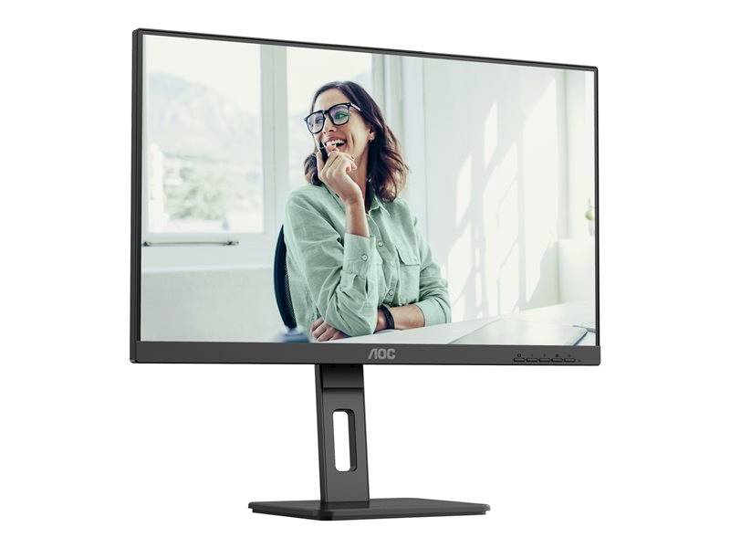 Ein Computer-Monitor zeigt eine lächelnde Frau mit Brille im grünen Hemd vor einem Fenster, im Büro sitzend.