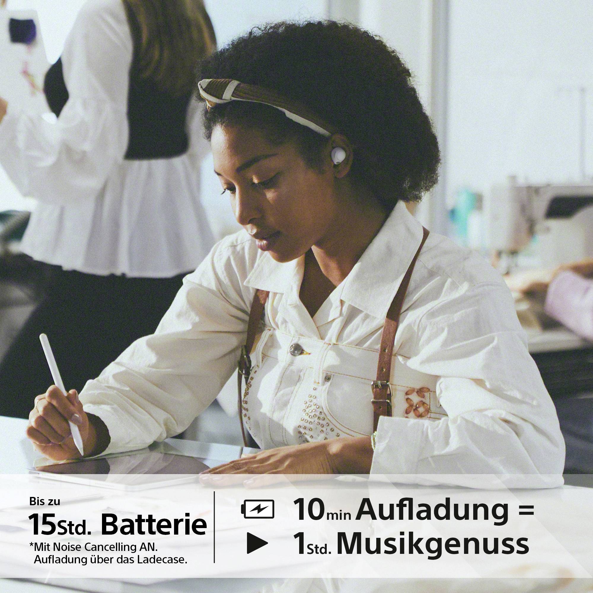 Eine Frau sitzt an einem Tisch und trägt kabellose Kopfhörer. Text unten: 'Bis zu 15 Std. Batterie', '10 Min. Aufladung = 1 Std. Musikgenuss'.