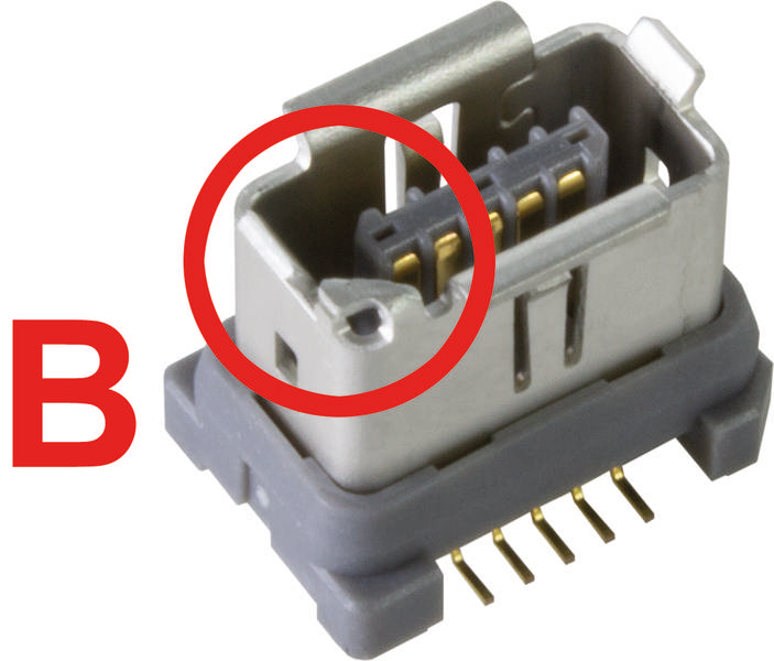 Ein Steckverbinder mit sechs goldenen Pins, teilweise von einem roten Kreis umgeben, neben einem großen roten Buchstaben 'B'.