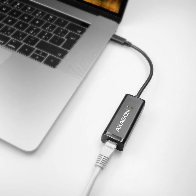 Ein Laptop ist mit einem Ethernetkabel verbunden, das über einen 'AXAGON'-Adapter angeschlossen ist.