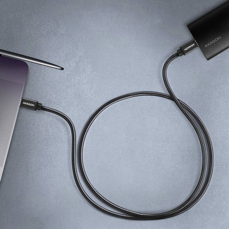 Ein schwarzes USB-Kabel verbindet einen Laptop mit einem externen Gerät. Beide Stecker tragen die Aufschrift 'AXAGON'.