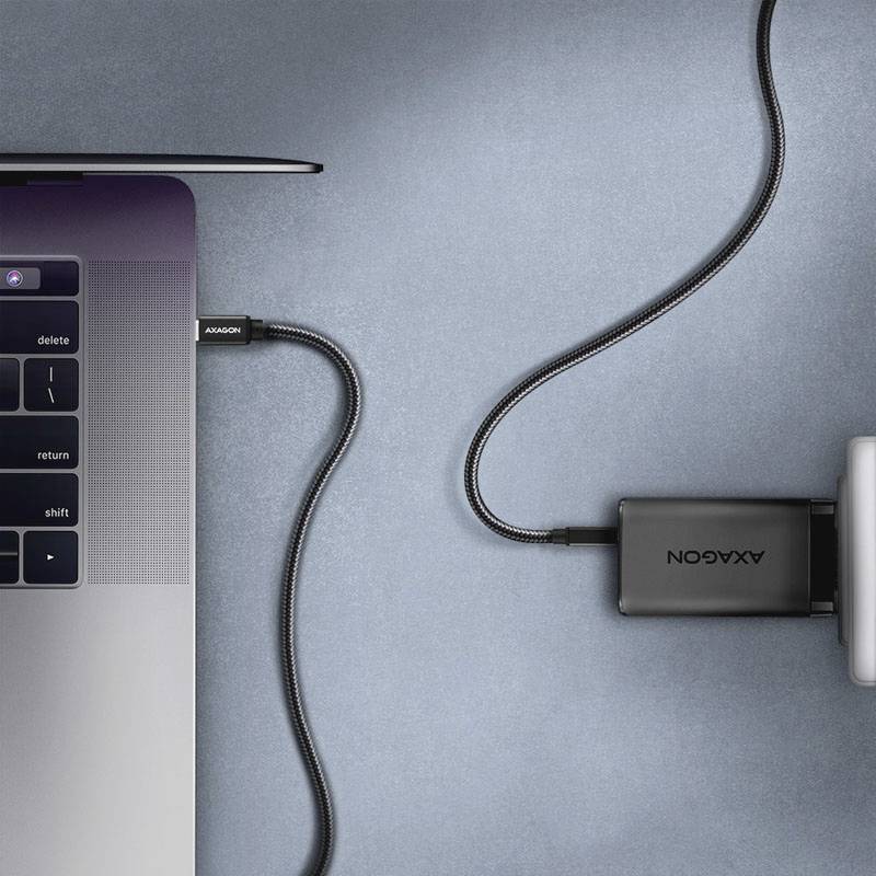 Laptop mit eingestecktem USB-C-Kabel und angeschlossenem Akkupack, das über ein weiteres Kabel verbunden ist.