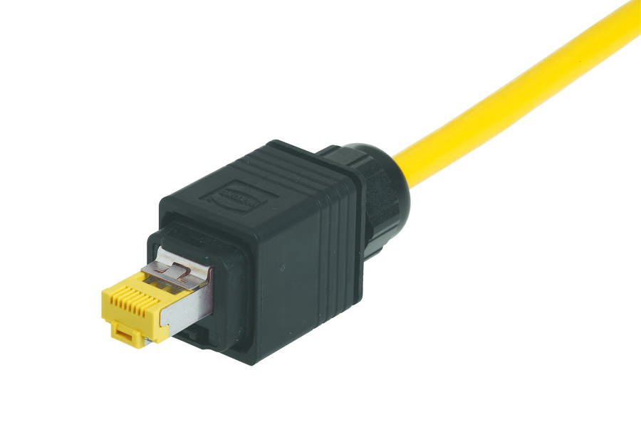 Ein gelbes Netzwerkkabel mit einem schwarzen Schutzstecker, geeignet für industrielle Anwendungen, liegt auf einem weißen Hintergrund.