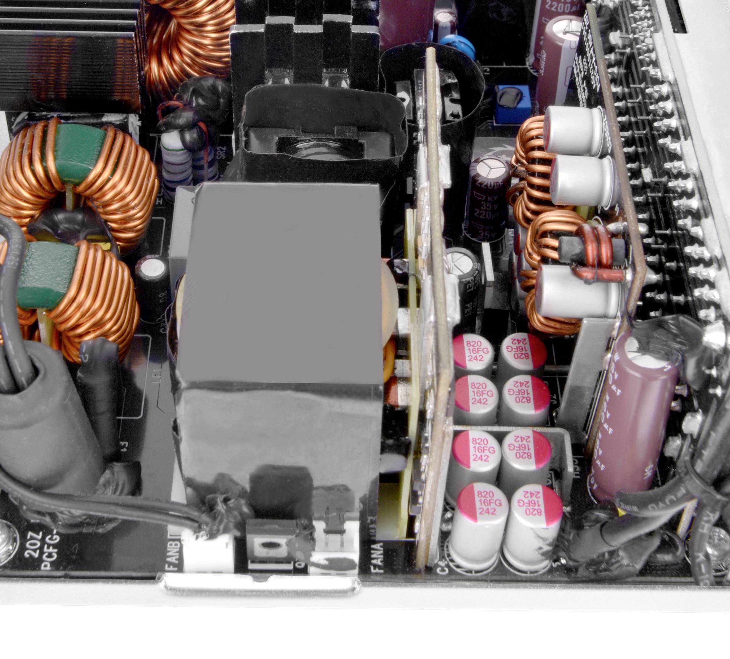 Elektronische Komponenten in einem Computer-Netzteil mit Spulen, Kondensatoren und Kühlkörpern, die für die Stromversorgung genutzt werden.