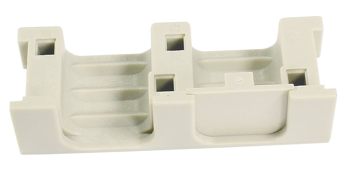 Ein cremefarbenes Kunststoffbauteil mit mehreren Aussparungen und Erhebungen, möglicherweise ein Halter oder Träger für technische Anwendungen.