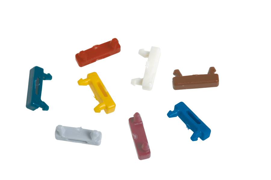 Mehrfarbige Plastikclips in verschiedenen Formen vor weißem Hintergrund.