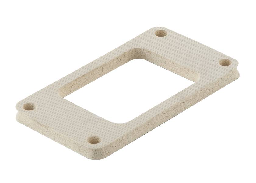 Rechteckige, beige Dichtung mit unterbrochener Mitte und vier Befestigungslöchern an den Ecken, aus strukturiertem Material.