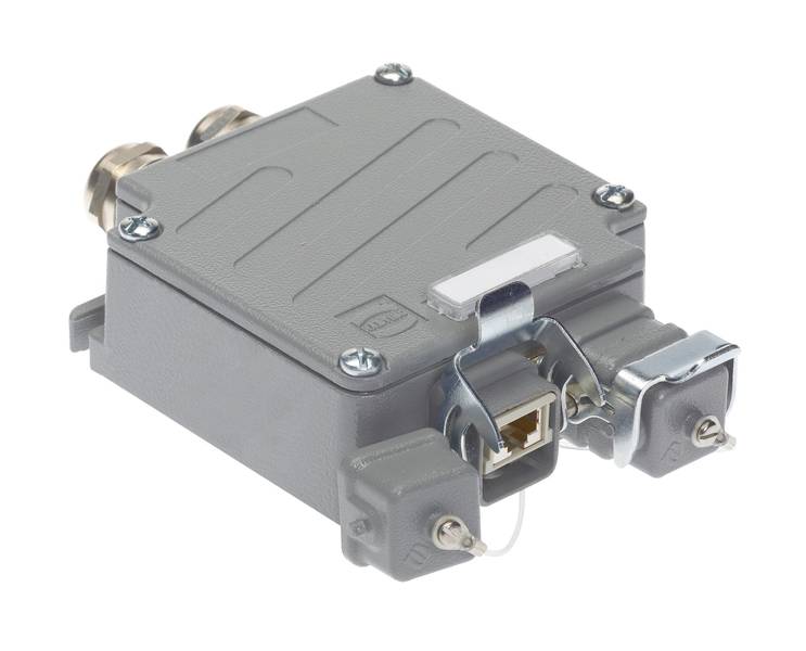 Graues, rechteckiges Elektronikmodul mit zwei Anschlussbuchsen und Schraubbefestigungen. Es dient zur Verbindung und Signalübertragung.