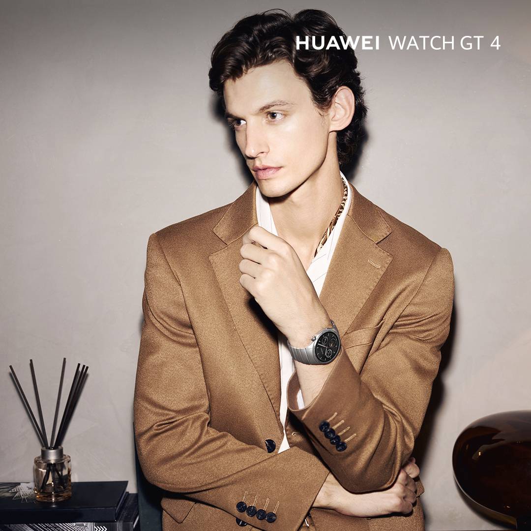 Ein Mann trägt eine elegante Uhr am Handgelenk, bekleidet mit einem braunen Blazer. Oben rechts der Text: 'HUAWEI WATCH GT 4'.