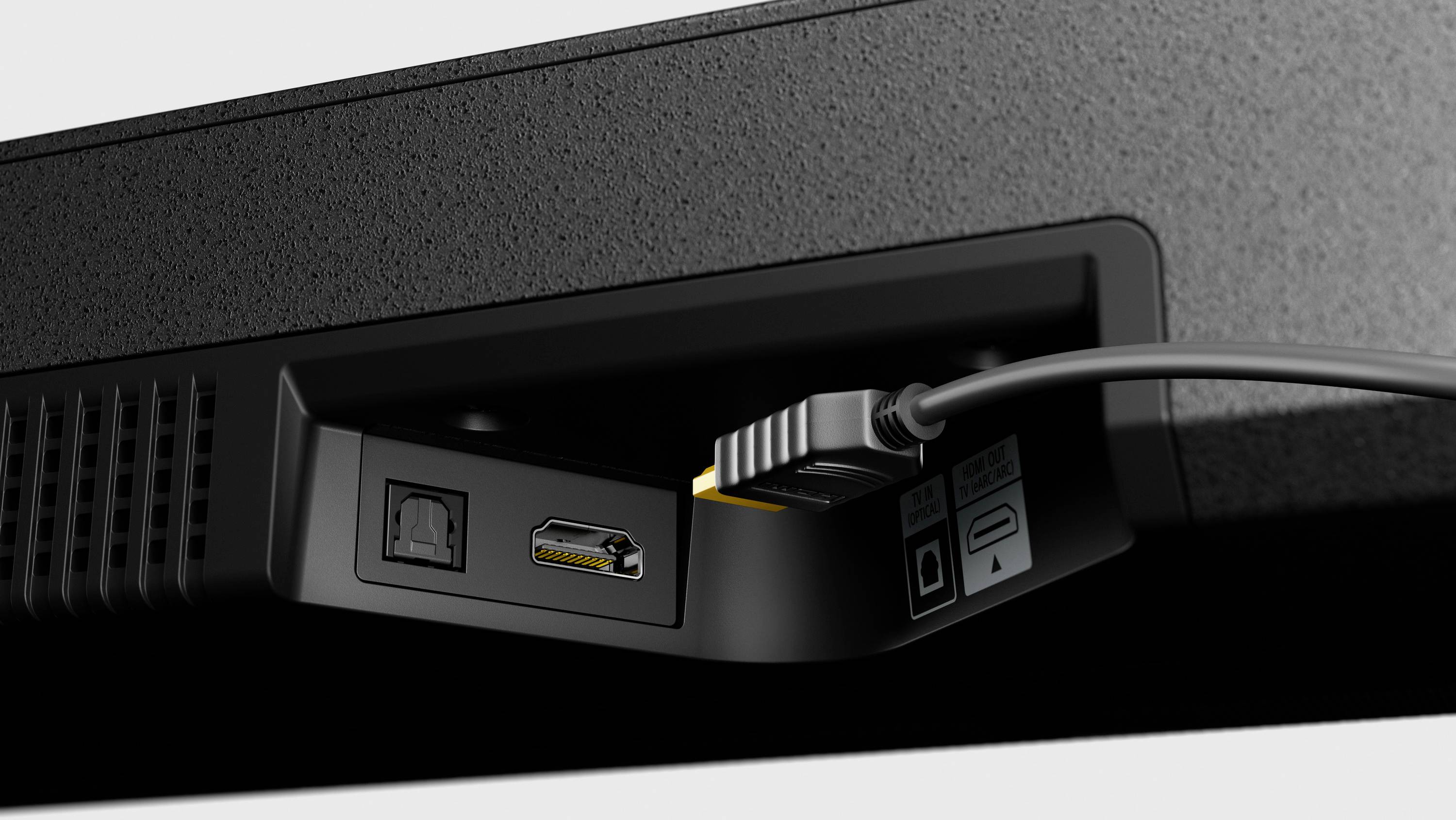 Ein HDMI-Kabel ist an den HDMI-Eingang eines elektronischen Geräts angeschlossen. Daneben befindet sich ein optischer Audioanschluss.