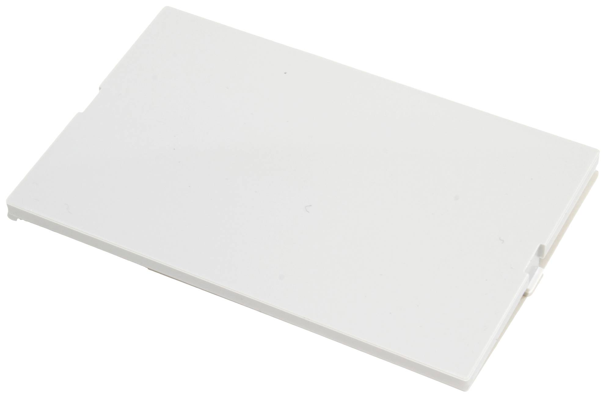 Ein leeres, rechteckiges, weißes Objekt, möglicherweise ein Plastikdeckel oder eine Abdeckung, liegt flach auf der Oberfläche.