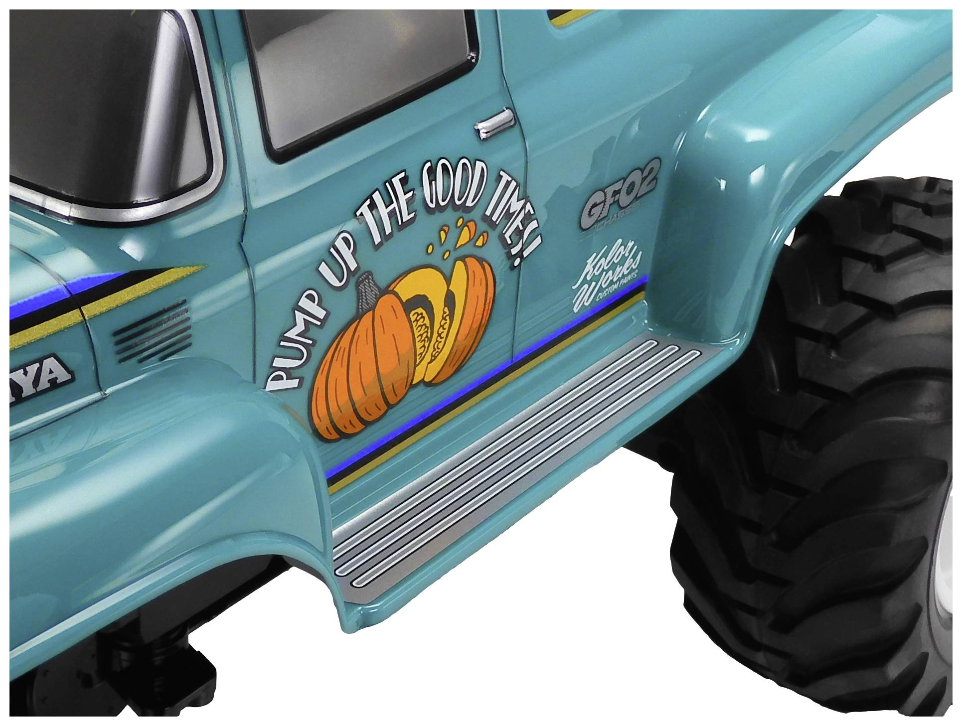 Spielzeug-Truck mit Aufkleber 'Pump up the good times!' und Kürbis-Design auf der Seite. Große Reifen betonen das robuste Aussehen.