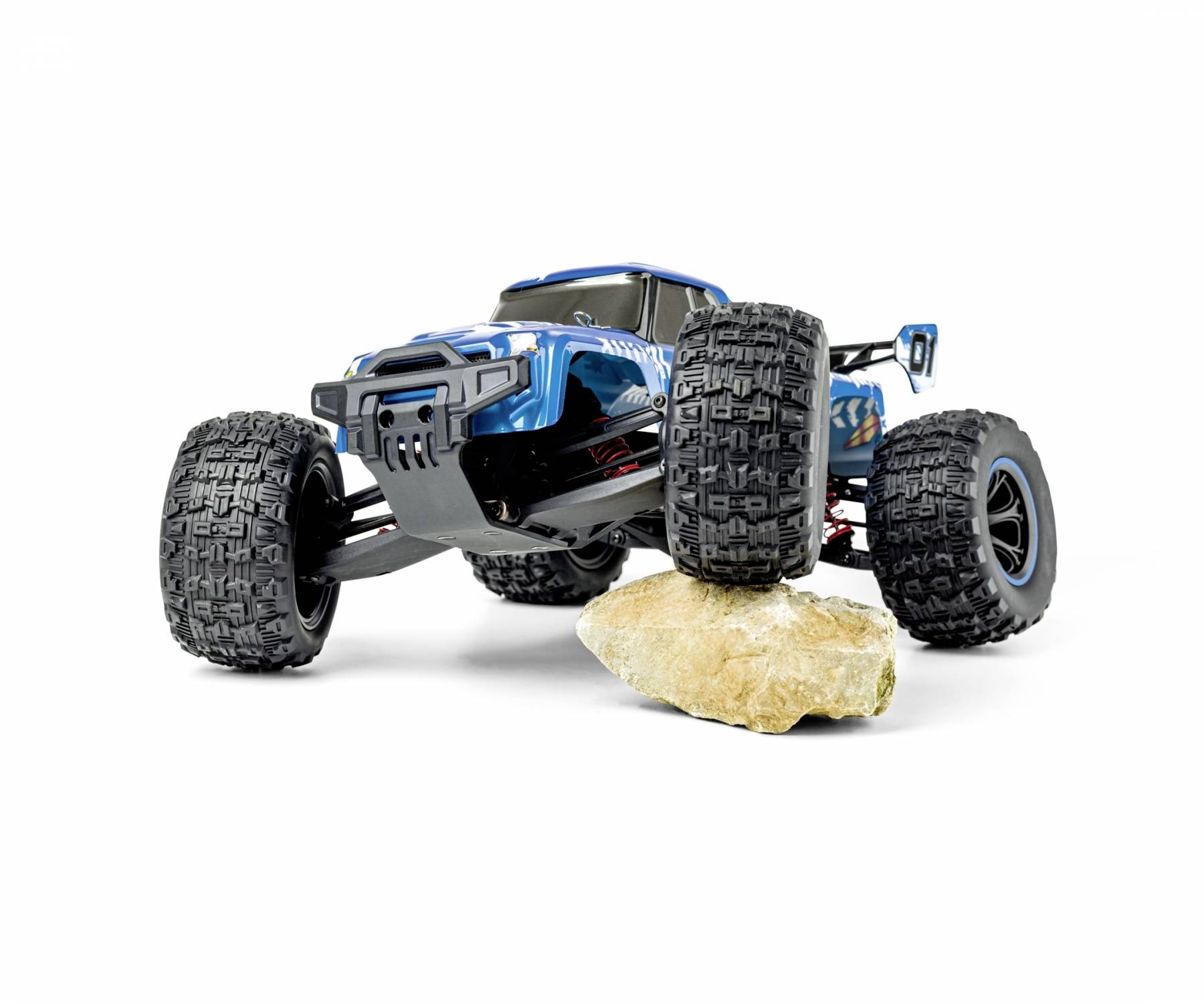 Ein blaues ferngesteuertes Auto mit großen Reifen fährt über einen Stein. Es zeigt die Offroad-Fähigkeit des Modells.