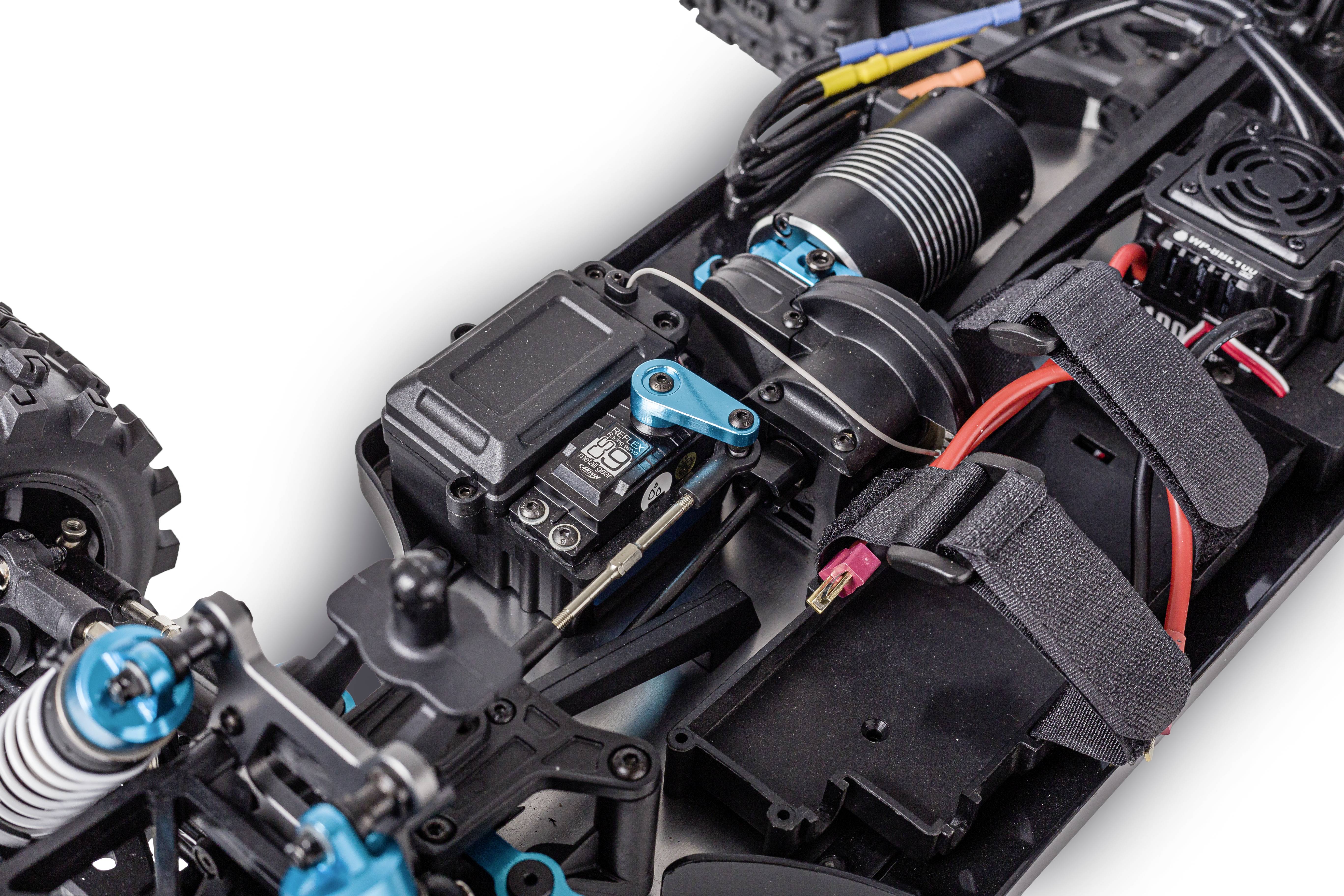 Nahaufnahme einer RC-Autoteile, zeigt Motor, Elektronik und Verkabelung. Fokus auf Antriebskomponenten und deren Anordnung.