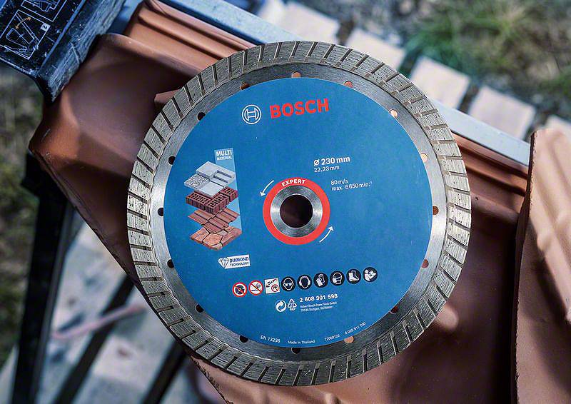Bosch Trennscheibe mit 230 mm Durchmesser, geeignet für Ziegel und Beton. Sie liegt auf einem Ziegel, bereit zum Einsatz.