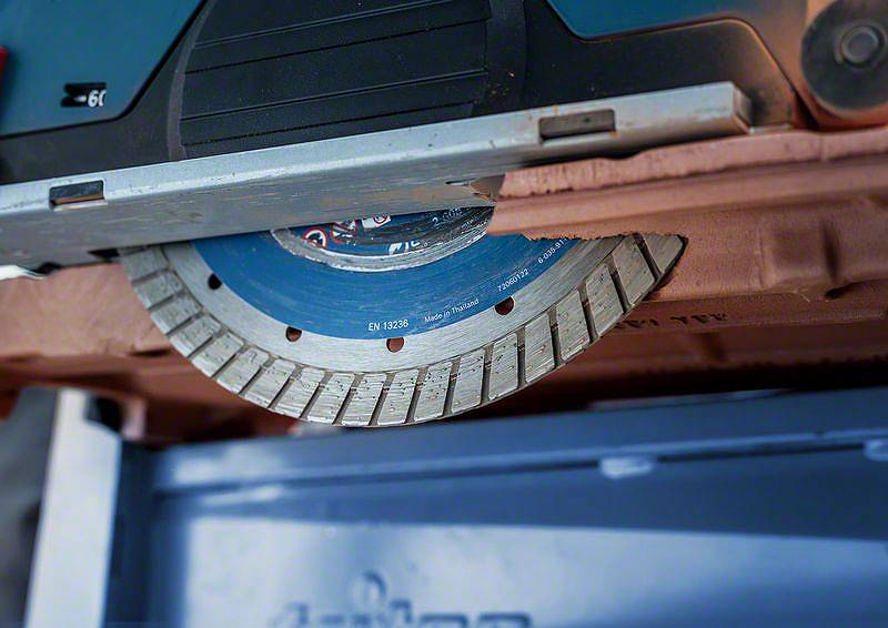 Nahaufnahme einer Kreissäge in Aktion, die durch ein Material schneidet. Die Metallzähne der Säge sind deutlich sichtbar.