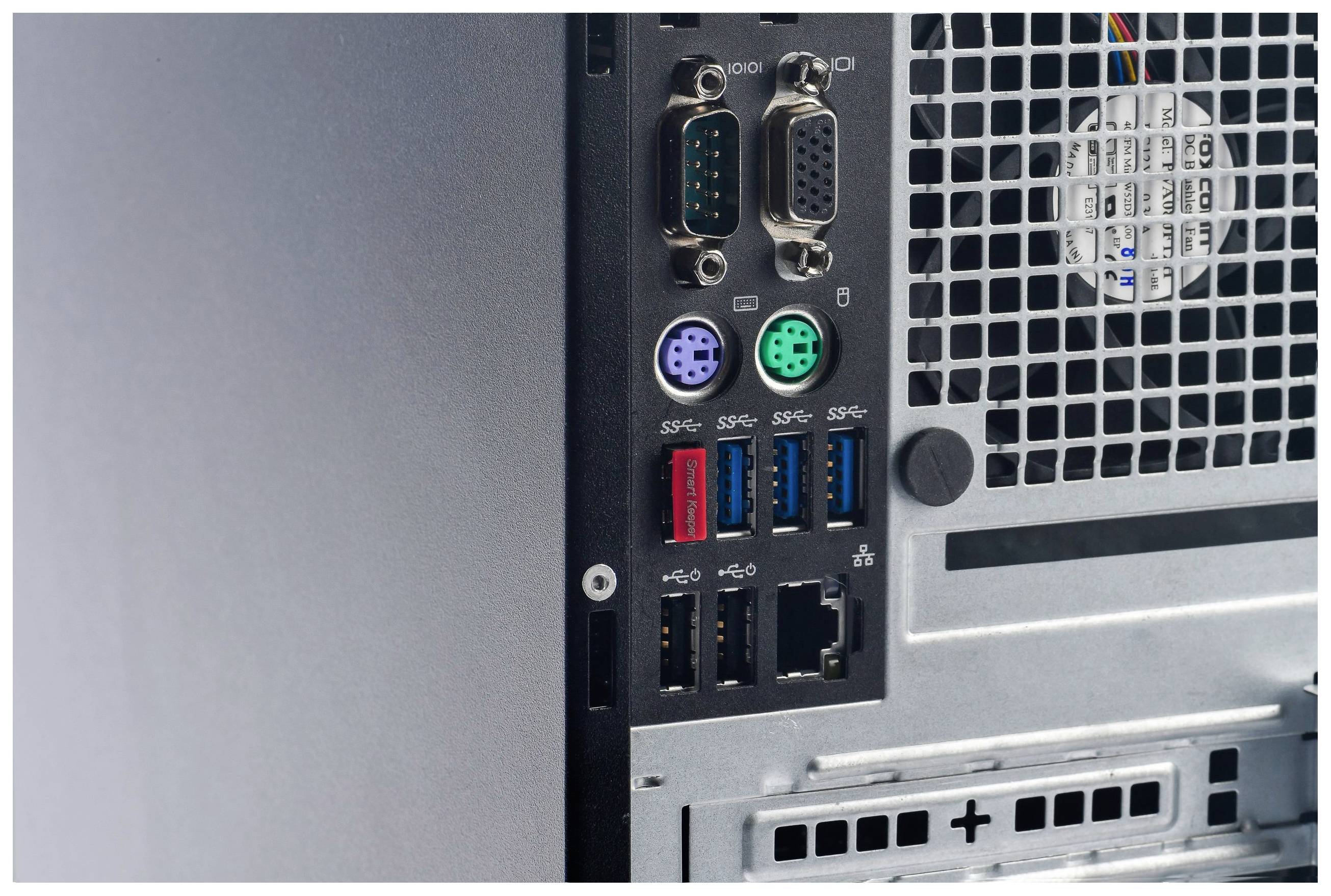 Rückseite eines Computergehäuses mit verschiedenen Anschlüssen, darunter serielle, PS/2-, USB-Ports und ein Lüftergitter.