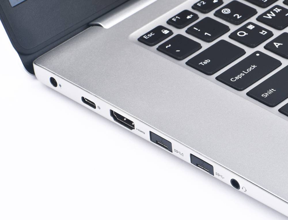 Nahaufnahme eines Laptops mit verschiedenen Anschlüssen, darunter HDMI, USB und Kopfhörerbuchse, die Kommunikation und Verbindung ermöglichen.