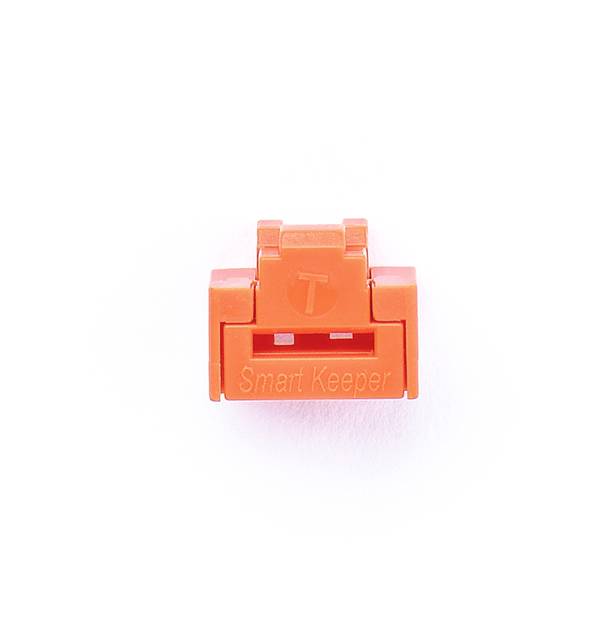 Ein orangefarbener USB-Port-Schutz mit der Aufschrift 'Smart Keeper'.