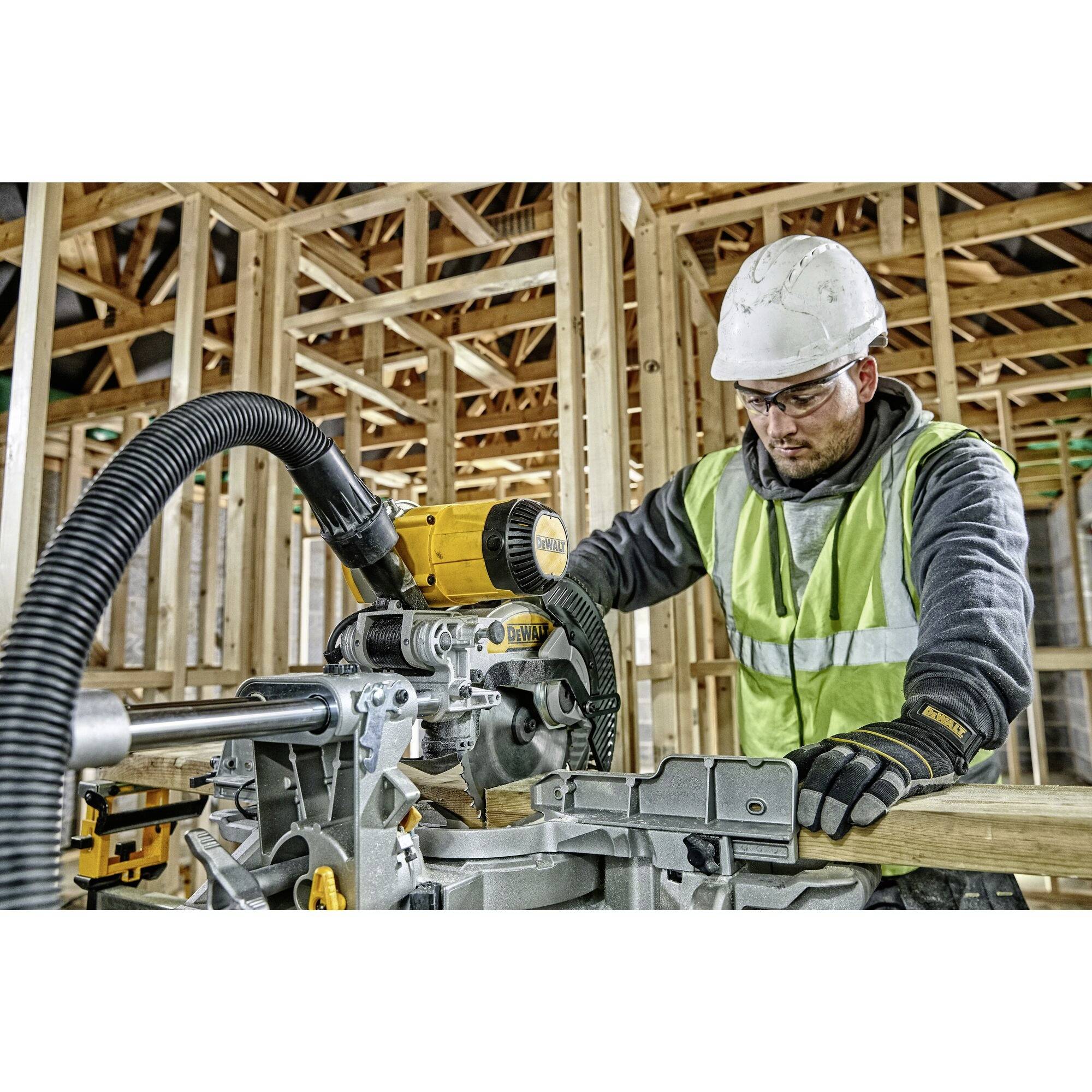 Bauarbeiter in Schutzkleidung bedient eine elektrische Säge in einem Holzrahmenbau, umgeben von Holzbalken und -trägern.