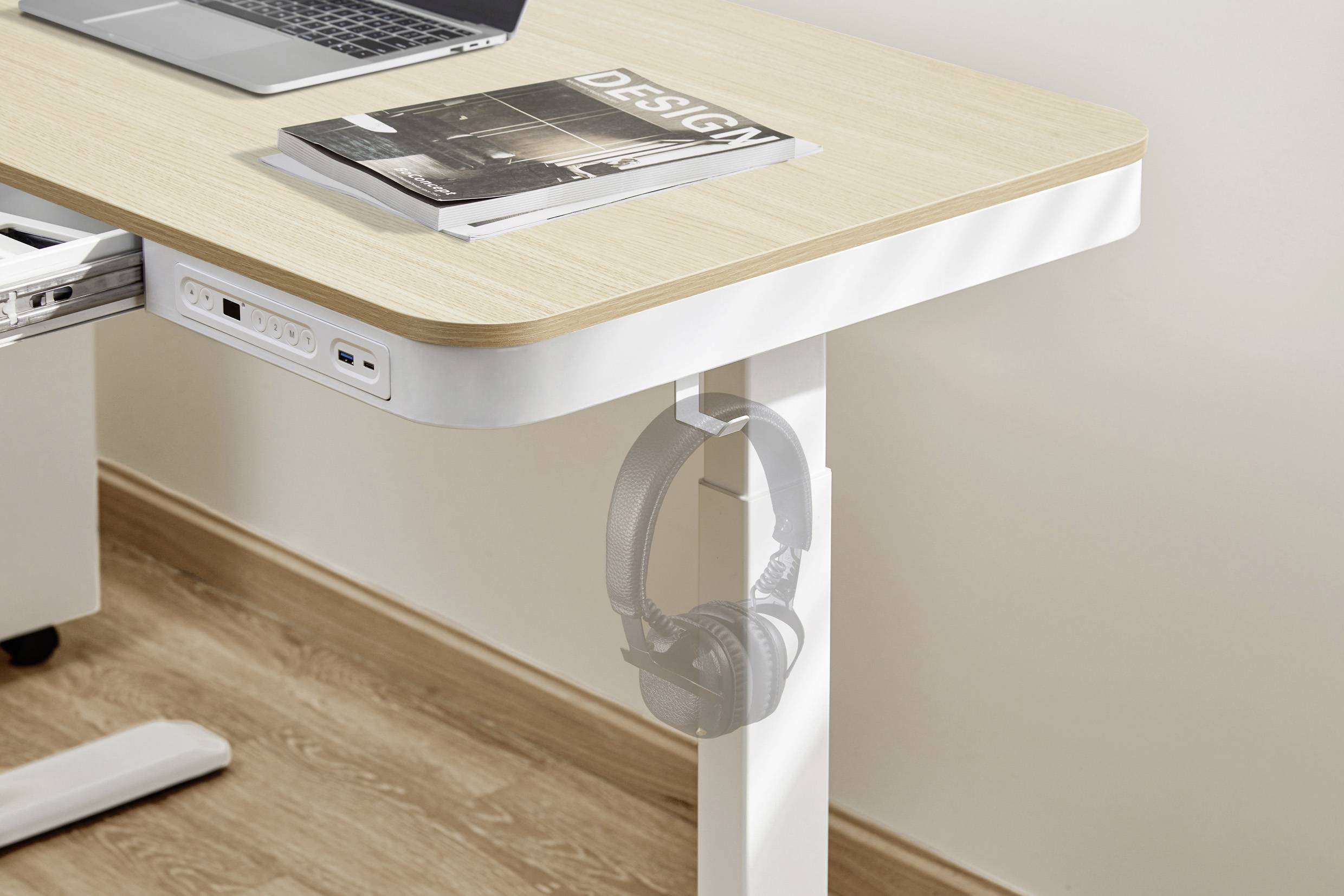 Schreibtisch mit Holzplatte, darauf ein Laptop und eine Zeitschrift mit dem Titel 'DESIGN'. An der Seite hängen Kopfhörer.