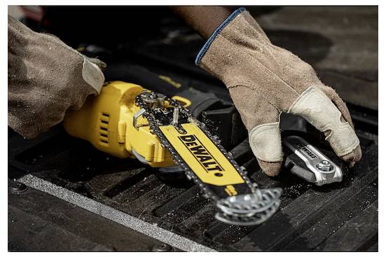 Eine Person mit Handschuhen bedient eine DeWalt-Kettensäge auf einer Holzoberfläche, wobei Holzspäne sichtbar sind und aktive Sägearbeiten angedeutet werden.