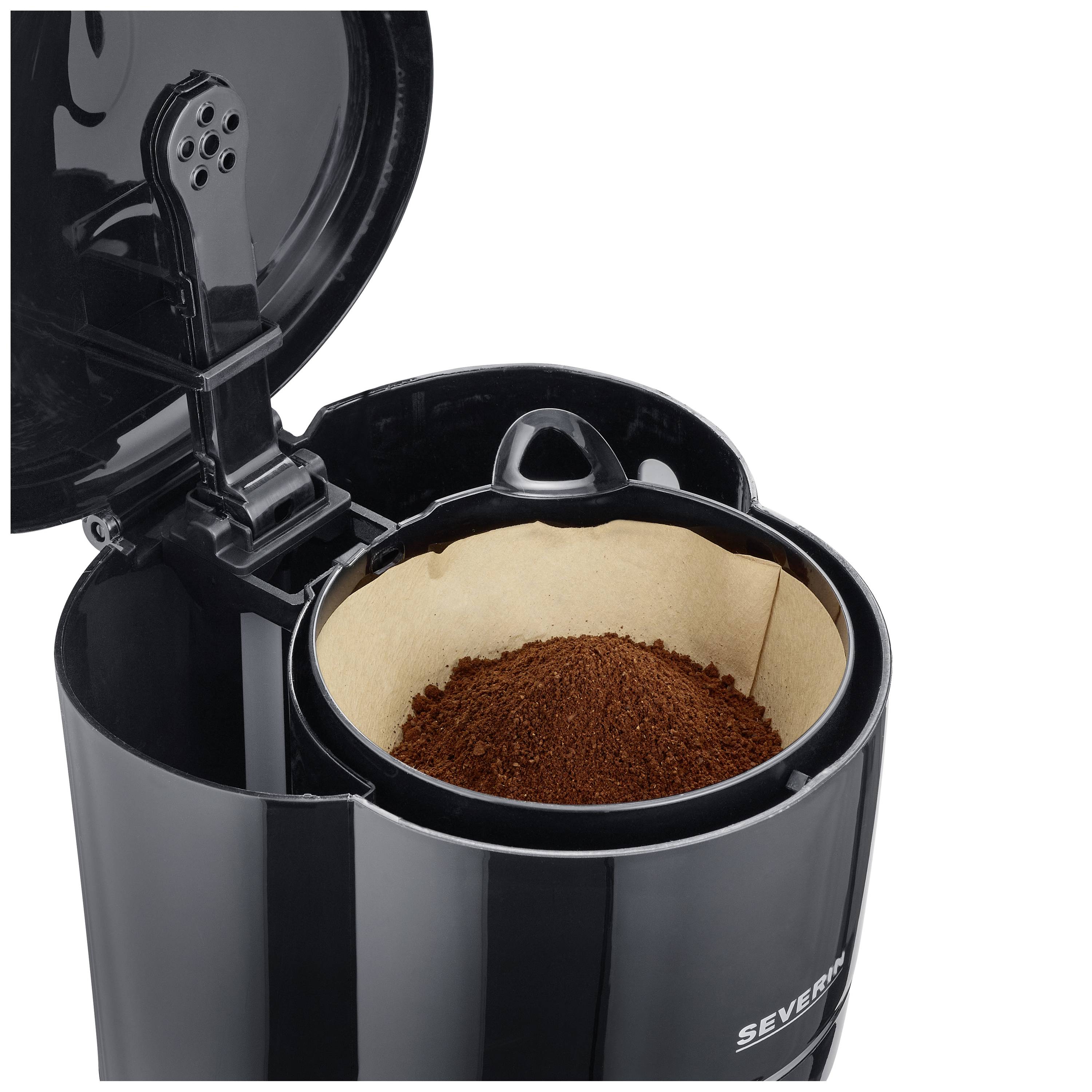 Schwarze Kaffeemaschine mit offenem Deckel, zeigt Filter mit gemahlenem Kaffee.