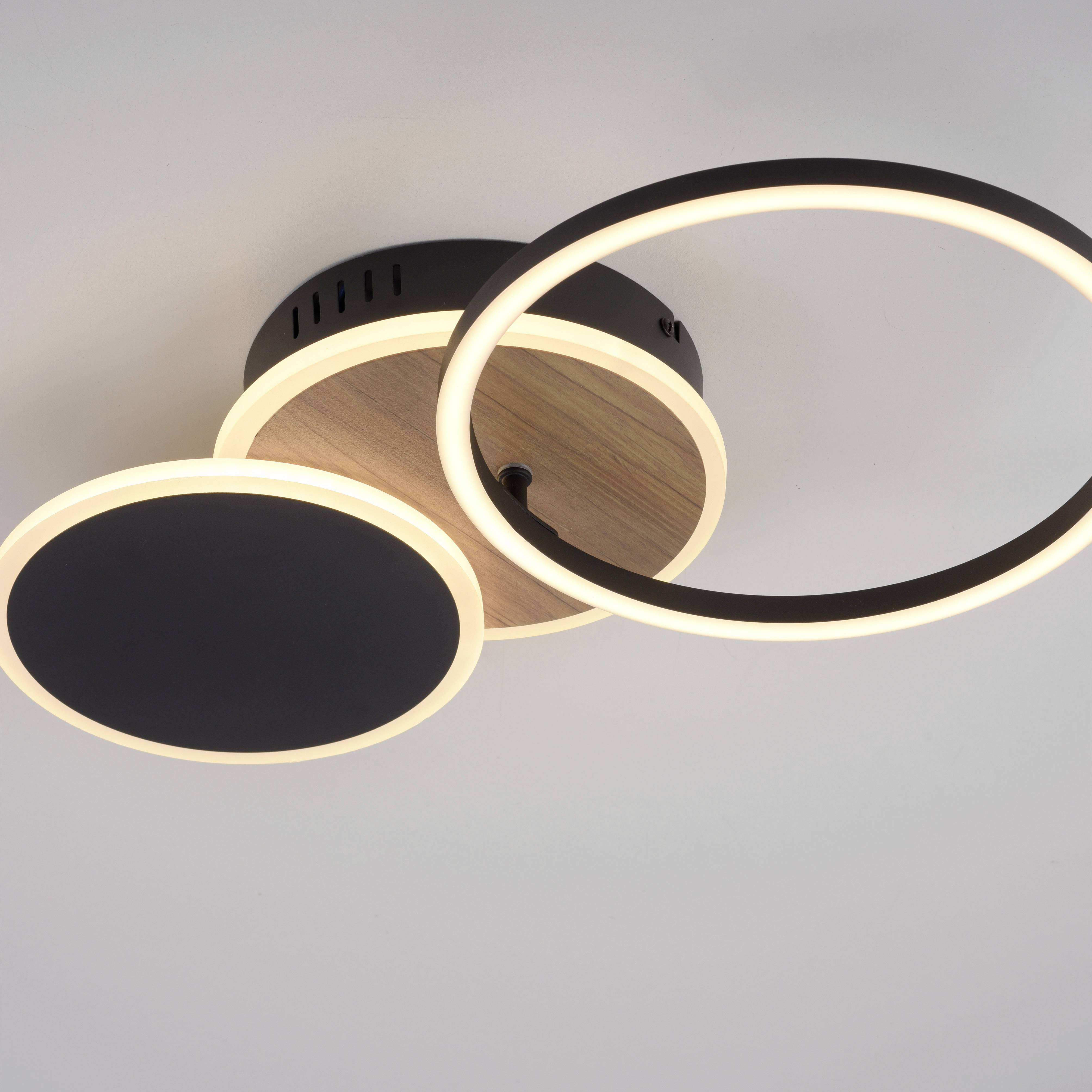 Moderner Deckenleuchter mit zwei runden LED-Paneelen in Schwarz und Holzoptik, die warmes Licht ausstrahlen.