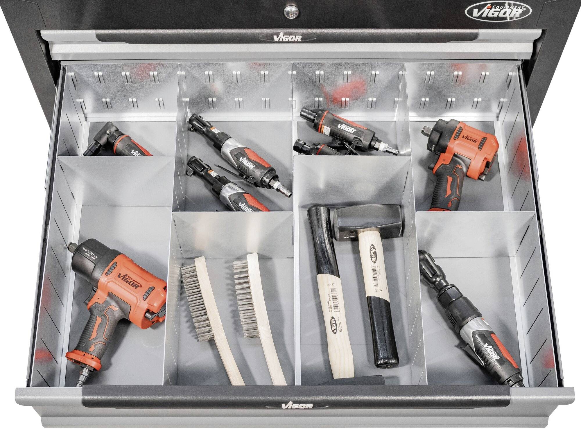 Offene Schublade mit Fächern. Enthält mehrere rote und schwarze Elektrowerkzeuge, zwei Holzhämmer und drei Drahtbürsten.