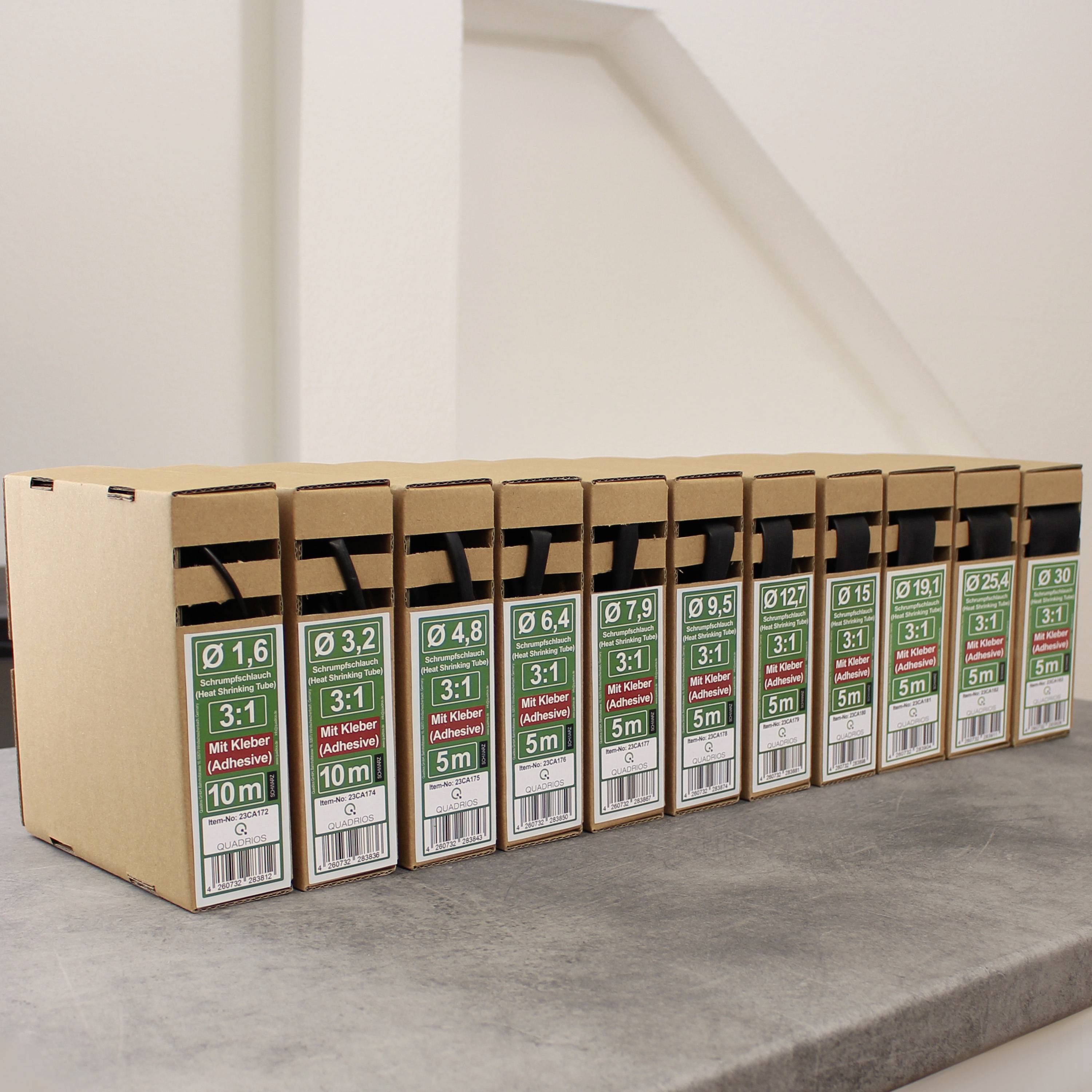 Elf Pappboxen mit verschiedenen Klebstoffdispensern, sortiert nach Größe von Ø 1,6 bis 10,2 mm. Jede Box enthält 5 bis 10 Meter Kleber.