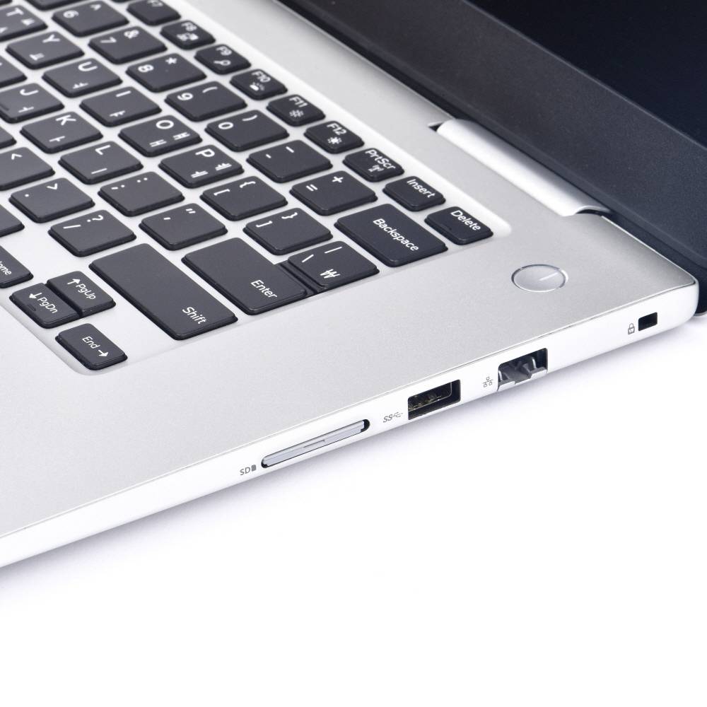 Ein silberner Laptop mit schwarzer Tastatur, seitlich gesehen. Zu sehen sind USB- und Netzanschlüsse.