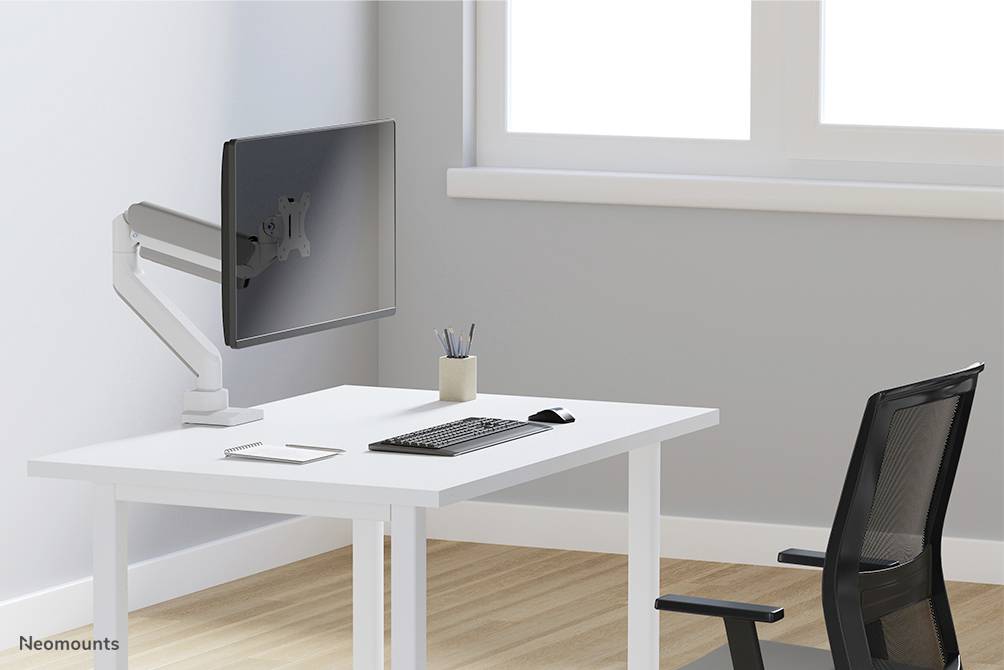 Ein moderner, minimalistisch eingerichteter Arbeitsplatz mit einem Monitor an einem Arm, einer Tastatur, Maus, Notizblock und Stiftbecher.