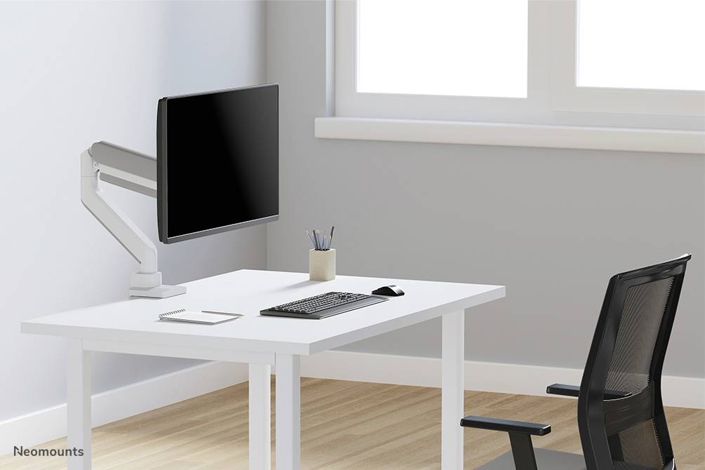 Ein minimalistischer Arbeitsplatz mit einem weißen Tisch, darauf ein Monitor am Gelenkarm, Tastatur, Maus, Stiftehalter; schwarzer Stuhl.