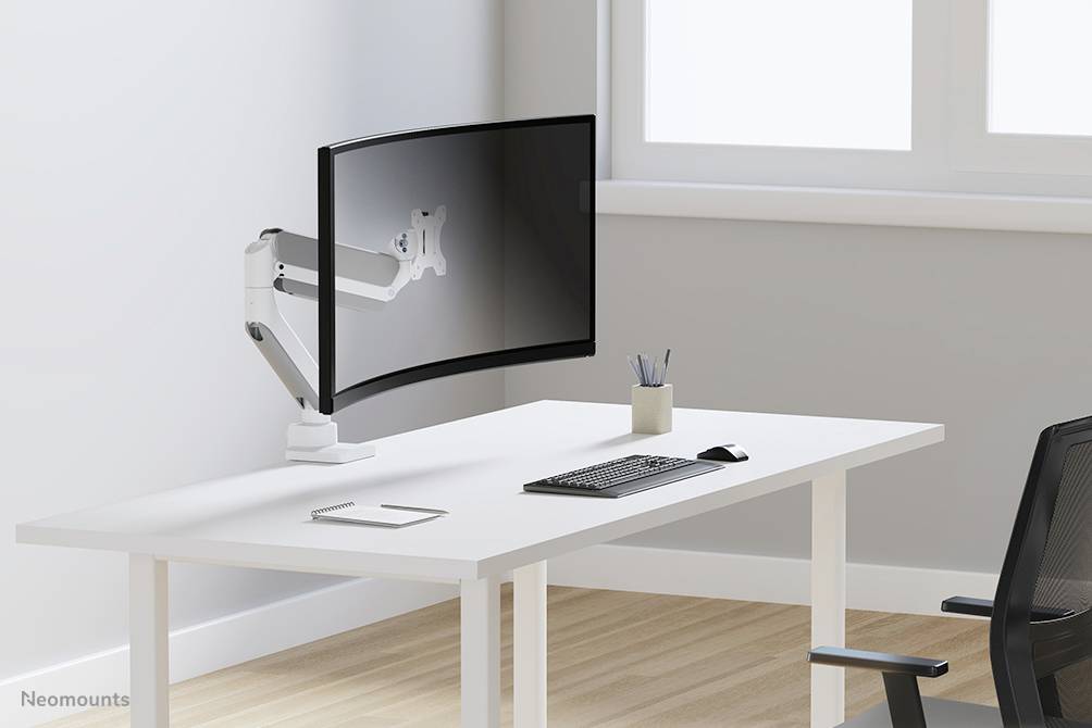 Ein moderner Schreibtisch mit einem großen, gebogenen Monitor auf einem verstellbaren Arm, Tastatur, Maus und Stifthalter.