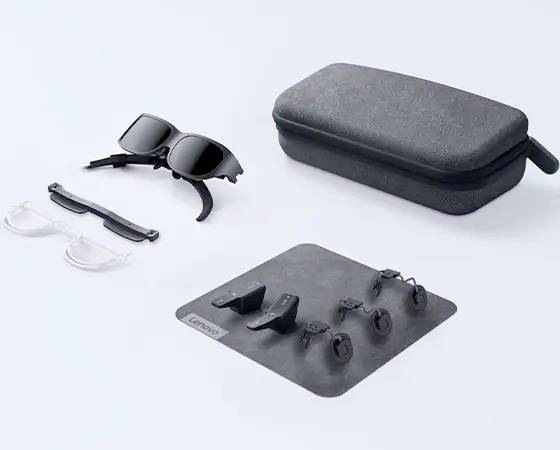 Lenovo AR-Brillen-Set mit schwarzem Etui, zwei Brillen und mehreren zusätzlichen Komponenten auf grauer Unterlage präsentiert.