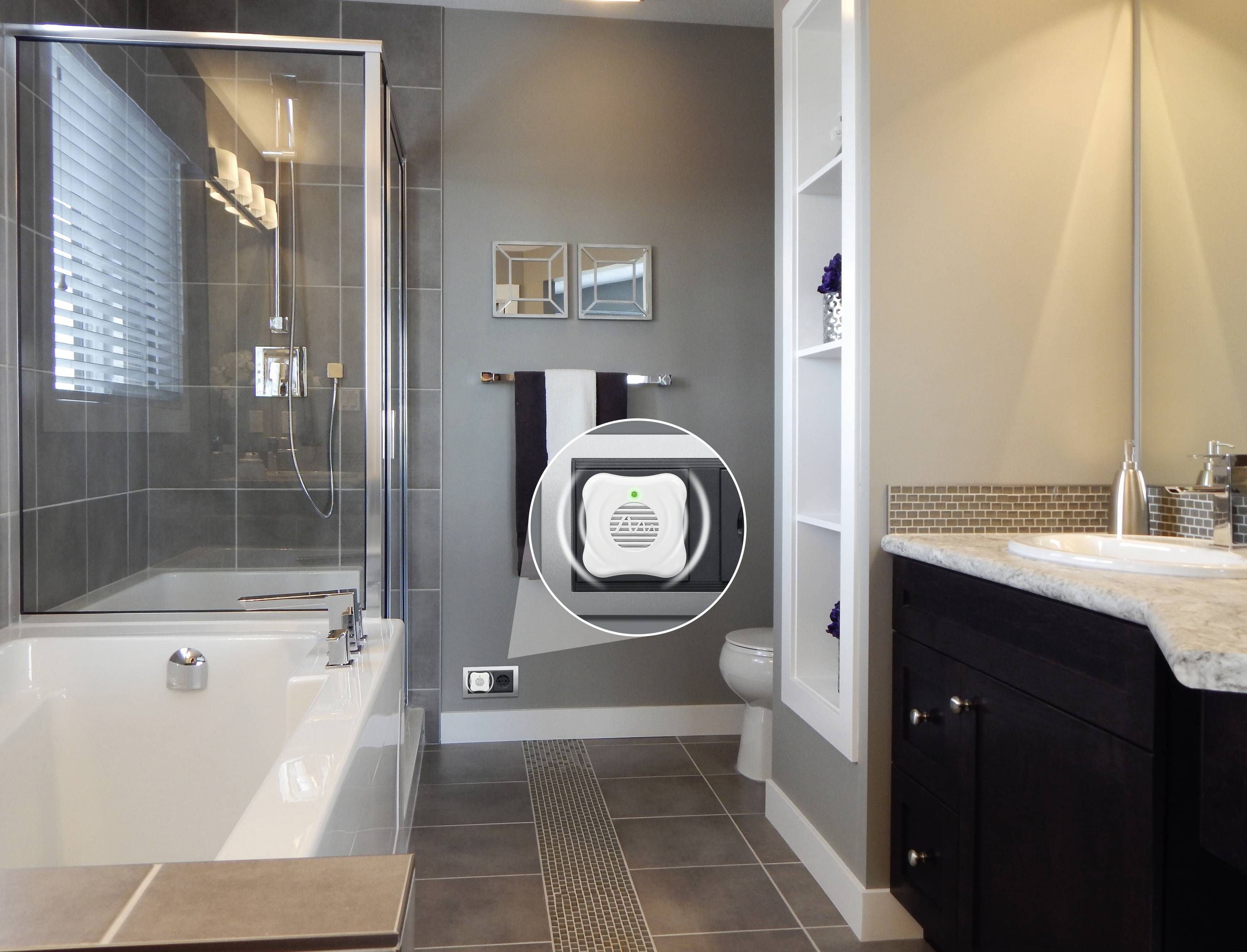 Ein modernes Badezimmer mit Badewanne, Waschbecken und Toilette. Ein kleines Gerät zur Luftqualitätserfassung ist an der Wand montiert.